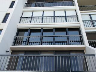 Roll-down shutters fitted across balcony openings on a multi-storey building
