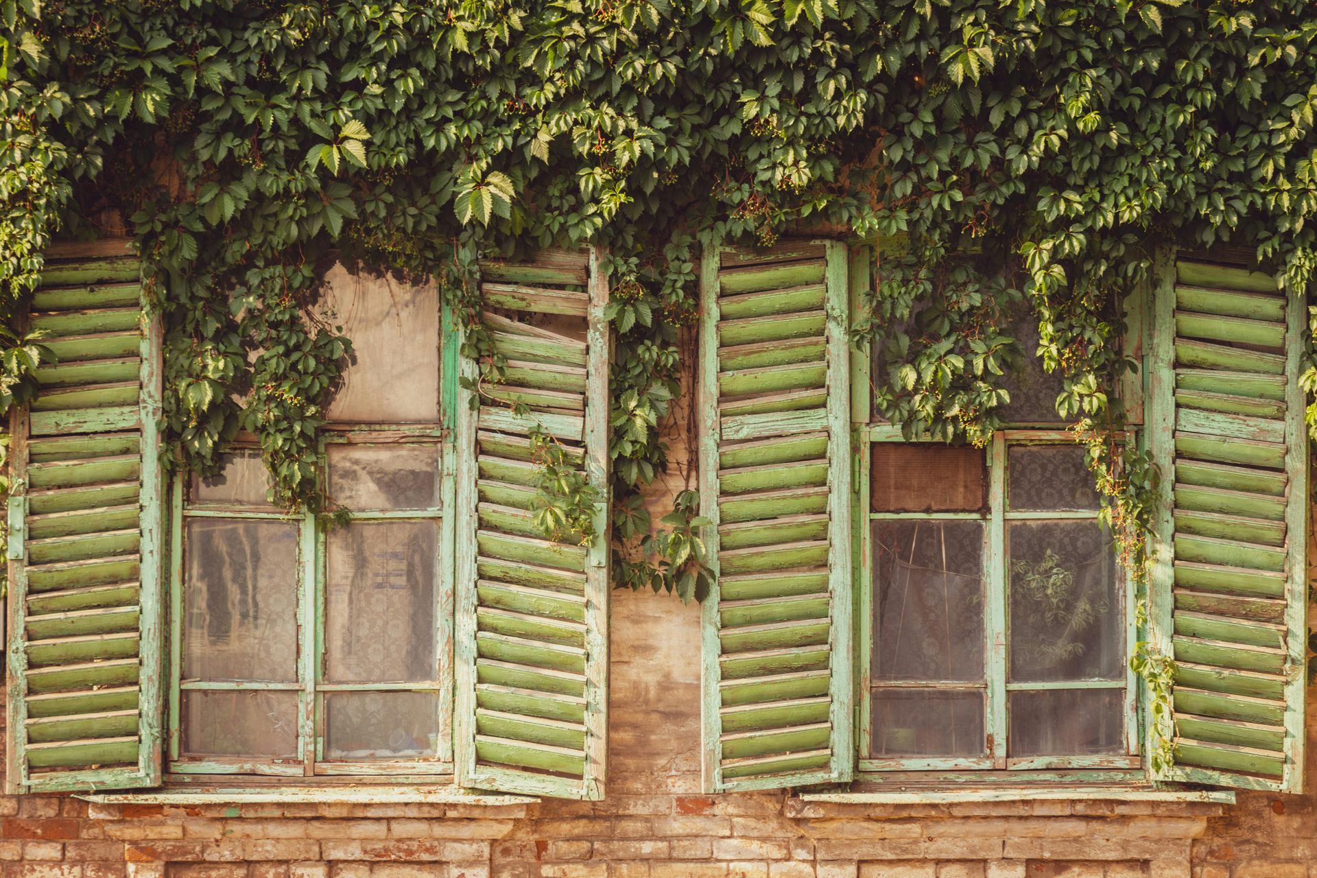 Weathered wooden shutters on a brick building