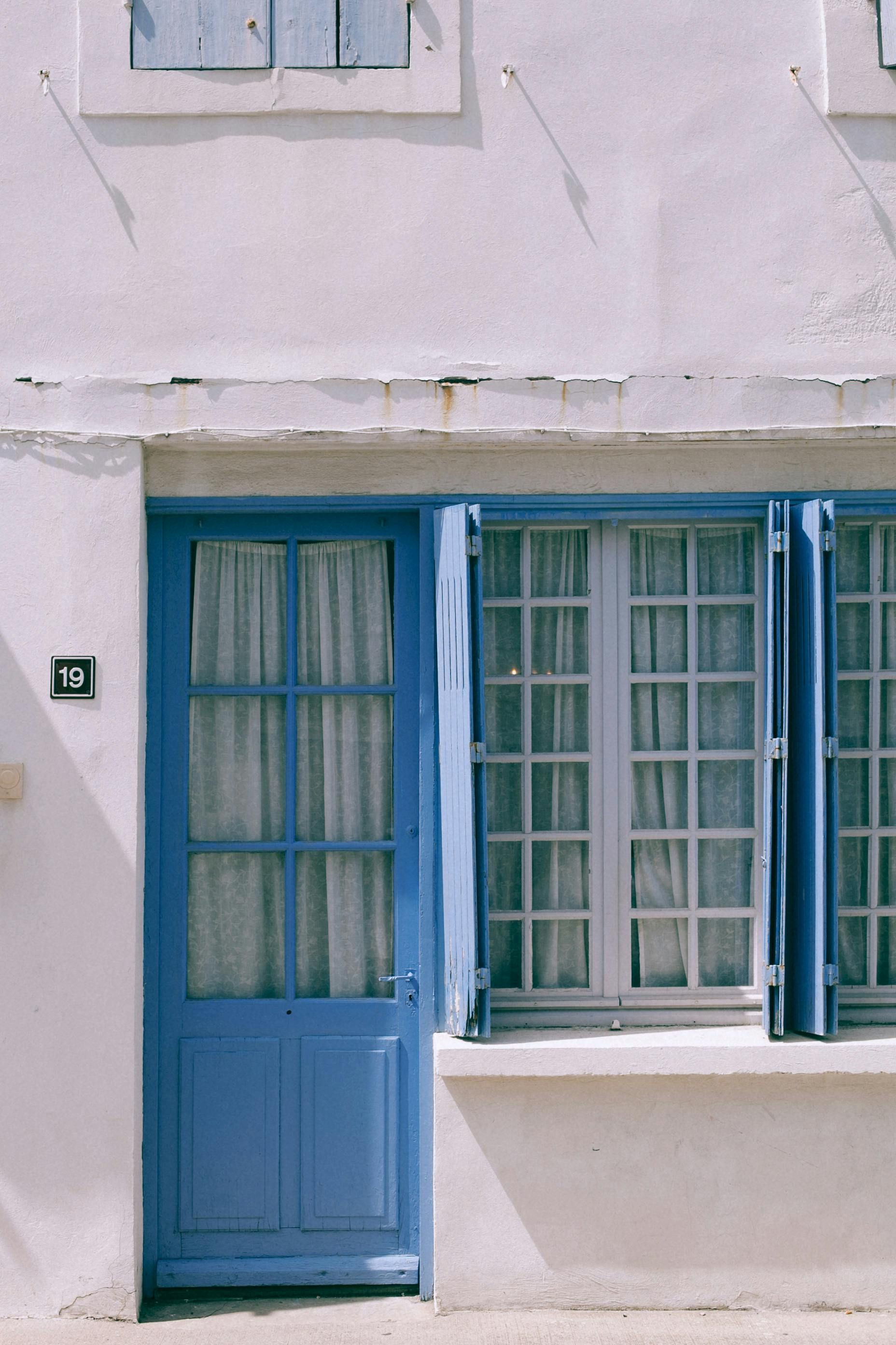 Hinged wooden shutters flanking a doorway and window